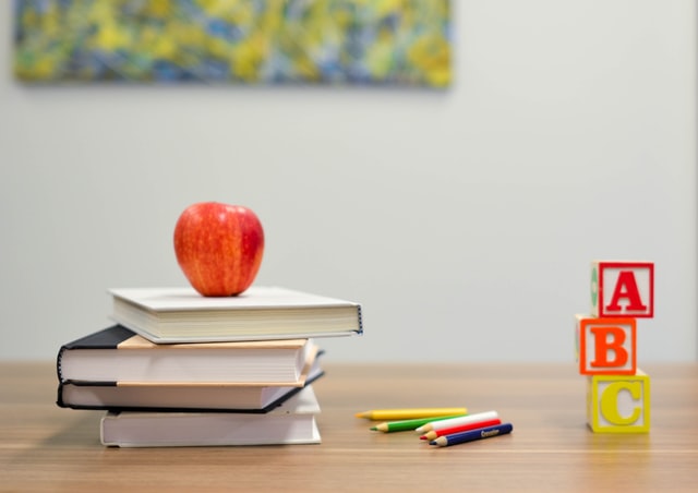 desk with books apple and pencils