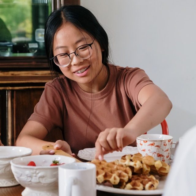 teen girl having waffles for breakfast