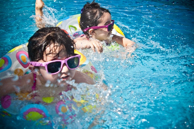 swimming children in pool with sunglasses