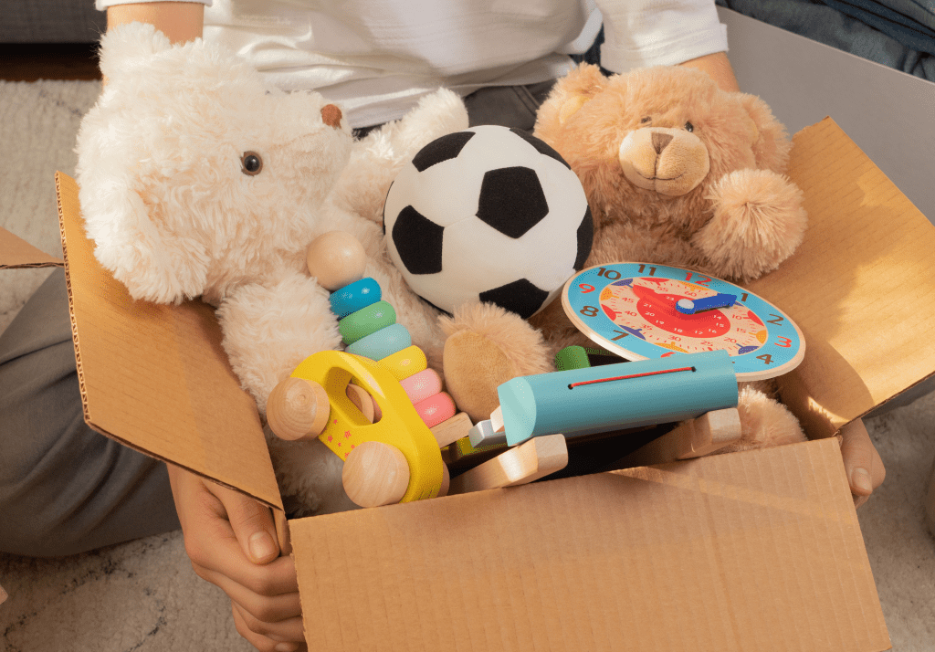 child holding a toybox full of toys